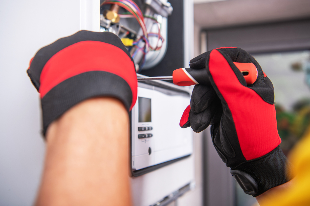 Technician’s hands repairing a home heating system